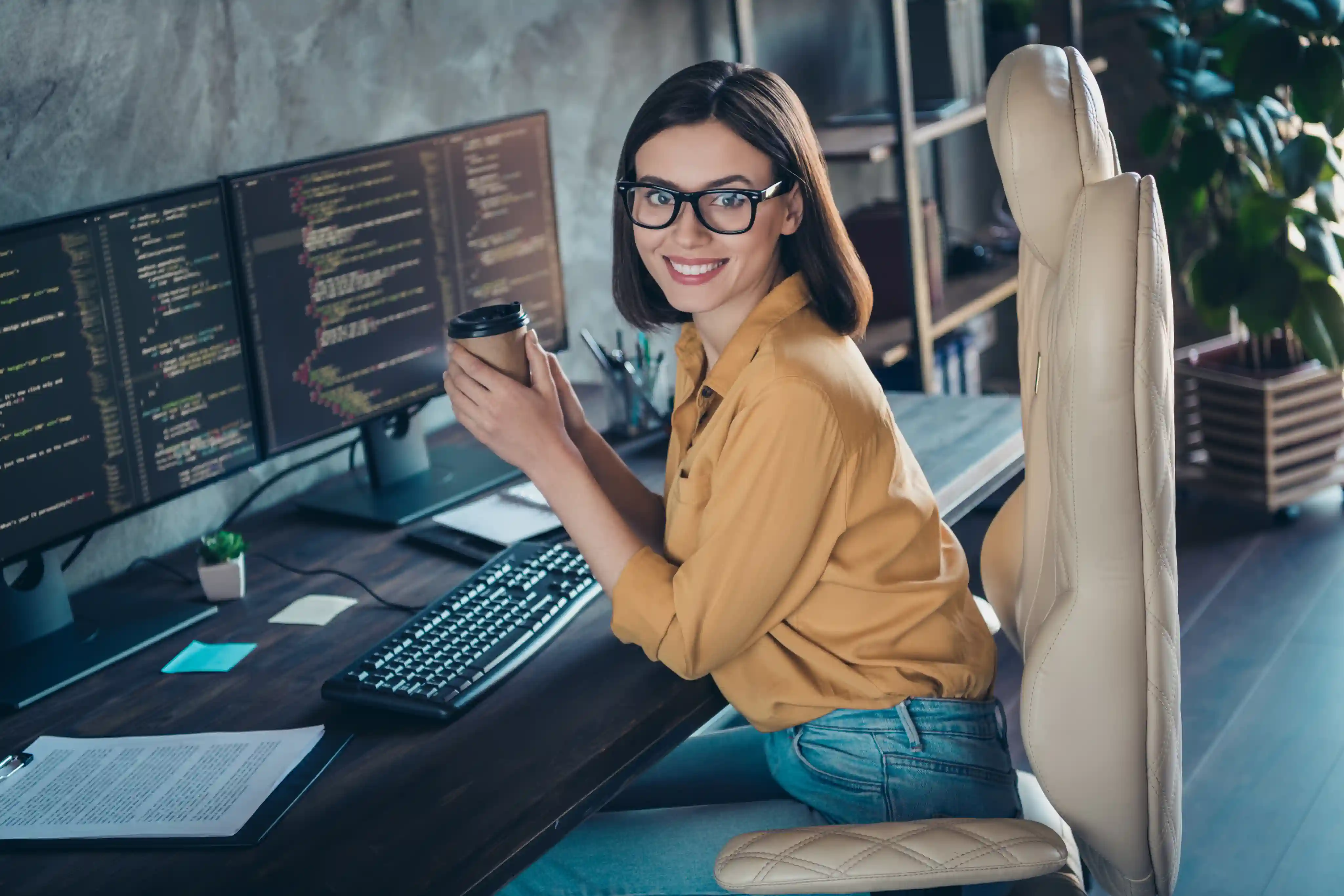 Programmeur die koffie drinkt aan haar bureau
